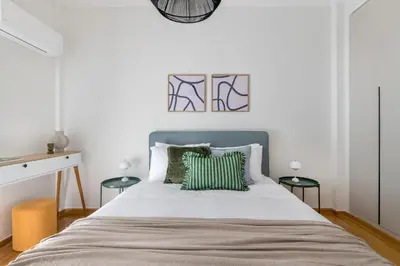 a bedroom with a bed with green and white pillows at Modern Athenian Nest near Kallimarmaro Stadium by UPSTREET in Athens