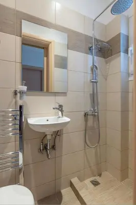 a bathroom with a sink and a shower at Modern Athenian Nest near Kallimarmaro Stadium by UPSTREET in Athens