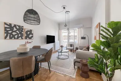 a living room with a table and a couch at Modern Athenian Nest near Kallimarmaro Stadium by UPSTREET in Athens