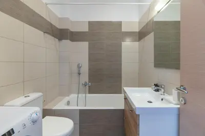 a bathroom with a sink and a toilet and a tub at Modern Athenian Nest near Kallimarmaro Stadium by UPSTREET in Athens