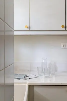 a kitchen counter with four empty glasses on it at Casa Riviera-Newly Renov 2Br Luxury Apt near Sea in Athens