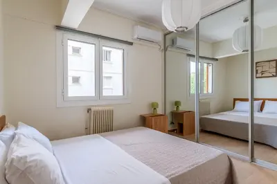 a bedroom with two beds and two windows at Casa Riviera-Newly Renov 2Br Luxury Apt near Sea in Athens