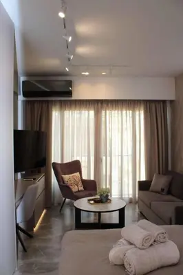 a living room with a couch and a table and a tv at Athens Central Studios 1 in Athens