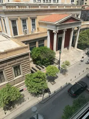 a building with a car parked in front of a street at Athens Central Studios 1 in Athens