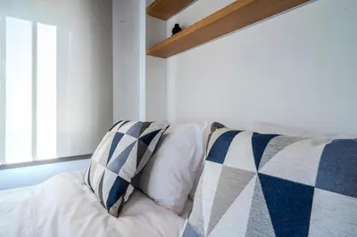 a white couch with blue and white pillows at Blum Residence Athens in Athens
