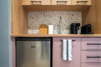a kitchen with pink cabinets and a refrigerator at Blum Residence Athens in Athens