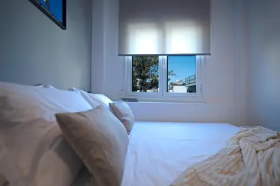 a bedroom with a white bed with a window at Blum Residence Athens in Athens