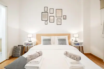 a bedroom with a large white bed with two lamps at Kolonaki Prestige - Greecing in Athens