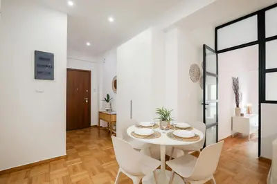 a white dining room with a white table and chairs at Kolonaki Prestige - Greecing in Athens