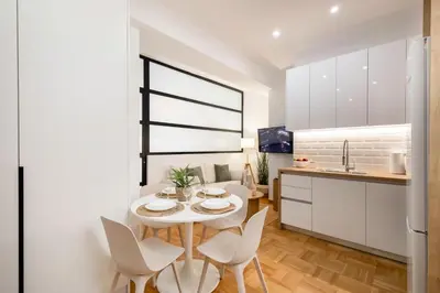 a kitchen and dining room with a white table and chairs at Kolonaki Prestige - Greecing in Athens