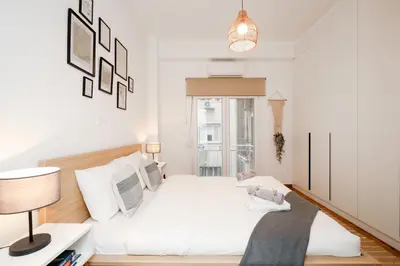 a white bedroom with a bed and a lamp at Kolonaki Prestige - Greecing in Athens
