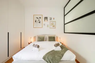 a bedroom with a white bed with two towels at Kolonaki Prestige - Greecing in Athens