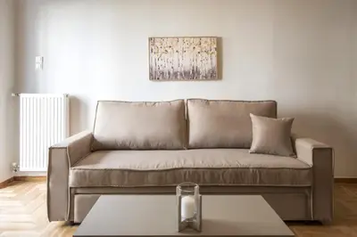a brown couch in a living room with a table at Urban Comfort Stay in Athens