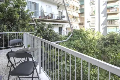 a chair and a table on the balcony of a building at Urban Comfort Stay in Athens