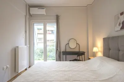 a white bedroom with a bed and a mirror at Urban Comfort Stay in Athens