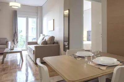 a dining room with a table and a living room at Urban Comfort Stay in Athens