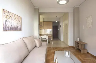 a living room with a white couch and a table at Urban Comfort Stay in Athens