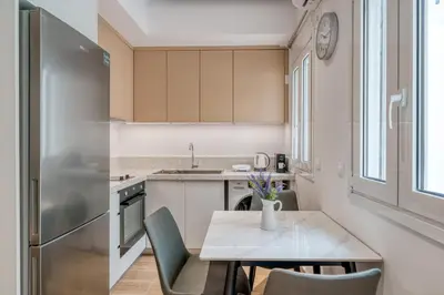 a kitchen with a table and chairs and a refrigerator at Near Pireas Port-Brand New Suite in Athens