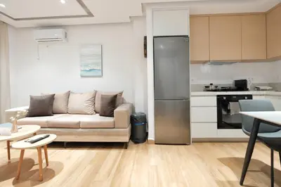 a living room with a couch and a kitchen at Near Pireas Port-Brand New Suite in Athens