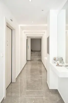 a hallway with white walls and a tile floor at Near Pireas Port-Brand New Suite in Athens