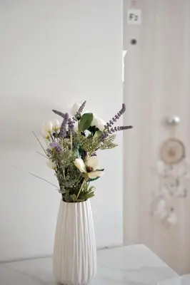 a white vase filled with flowers on a table at Near Pireas Port-Brand New Suite in Athens