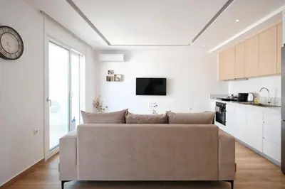 a living room with a couch and a clock on the wall at Near Pireas Port-Brand New Suite in Athens