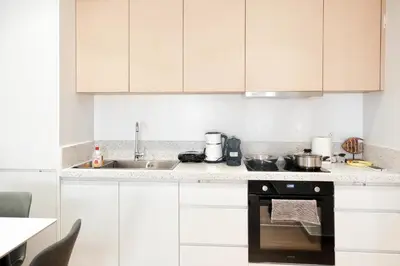 a kitchen with white cabinets and an oven at Near Pireas Port-Brand New Suite in Athens