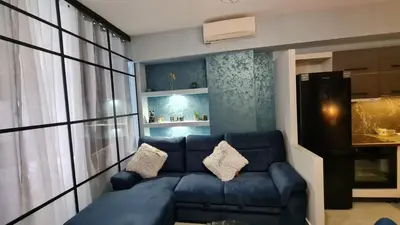 a living room with a blue couch in front of a window at Heart of Athens Luxury 2BR#8 in Athens