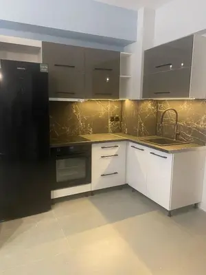 a kitchen with white cabinets and a black refrigerator at Heart of Athens Luxury 2BR#8 in Athens