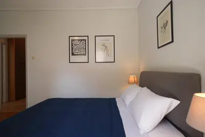 a bedroom with a bed and three pictures on the wall at Family Flat for 4 next to the Flisvos Marina by Filos Inc in Athens