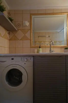 a bathroom with a washing machine and a sink at Family Flat for 4 next to the Flisvos Marina by Filos Inc in Athens
