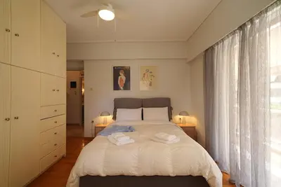 a bedroom with a bed with two towels on it at Family Flat for 4 next to the Flisvos Marina by Filos Inc in Athens