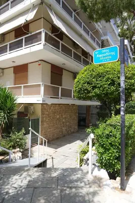 a blue street sign in front of a building at Family Flat for 4 next to the Flisvos Marina by Filos Inc in Athens