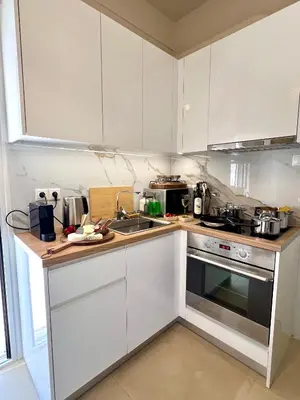 a kitchen with white cabinets and a stove top oven at AK Athens Fine Stay - Penthouse with Big Terrace and View - 2 min from Metro in Athens