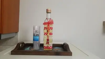 a bottle with a bow on top of a tray at Sunny apartment in the heart of Pireaus in Piraeus