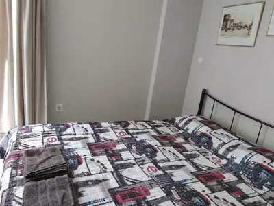 a bed with a quilt on it in a bedroom at Sunny apartment in the heart of Pireaus in Piraeus