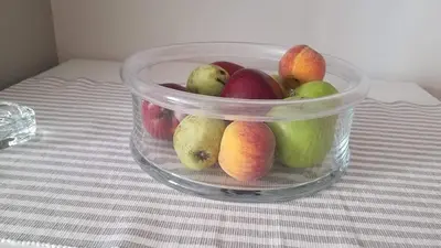 a plastic container of apples and pears on a table at Sunny apartment in the heart of Pireaus in Piraeus