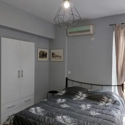 a bedroom with a bed and a ceiling fan at Sunny apartment in the heart of Pireaus in Piraeus