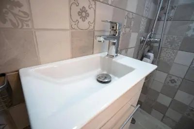 a white sink in a bathroom with a shower at Breezy Maisonette in Zea for 5 by Filos Inc in Piraeus