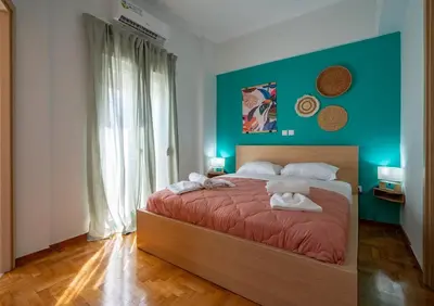 a bedroom with a large bed with a blue wall at Breezy Maisonette in Zea for 5 by Filos Inc in Piraeus