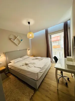 a bedroom with a bed and a desk and a window at Downtown Lux apartment in Athens