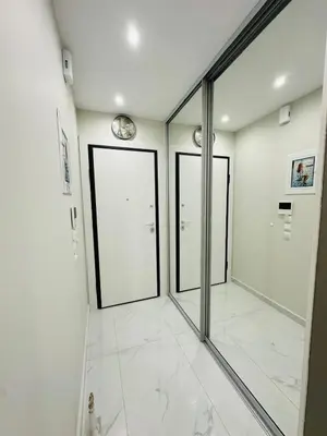 a hallway with mirrors and a clock on the wall at Downtown Lux apartment in Athens