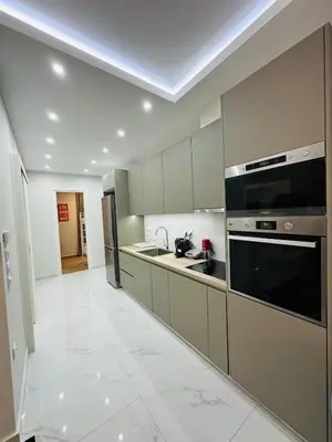 a kitchen with stainless steel appliances and white tile floors at Downtown Lux apartment in Athens