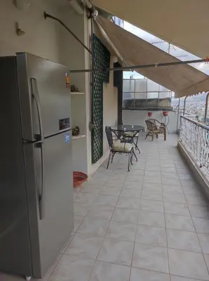 a refrigerator on a balcony with a table and chairs at Onix 4 in Athens