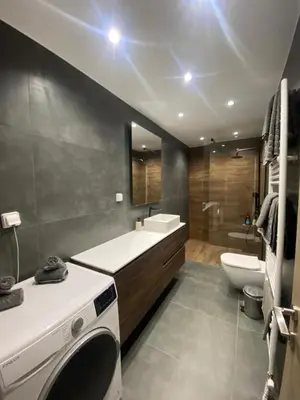 a bathroom with a sink and a washing machine in it at Comfort SpataAir Stay in Spáta