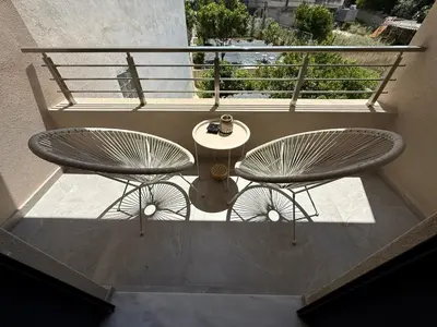 two metal chairs and a table on a balcony at Comfort SpataAir Stay in Spáta