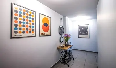 a hallway with paintings and a table with flowers on it at Chic New Apt with Acropolis View in Monastiraki in Athens