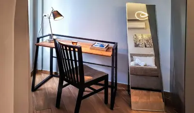 a desk with a chair and a lamp in a room at Chic New Apt with Acropolis View in Monastiraki in Athens