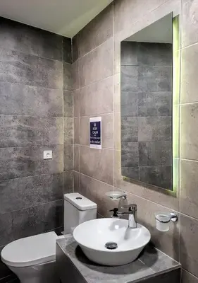 a bathroom with a sink and a toilet and a mirror at Chic New Apt with Acropolis View in Monastiraki in Athens