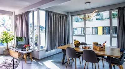 a dining room with a table and chairs and windows at Chic New Apt with Acropolis View in Monastiraki in Athens